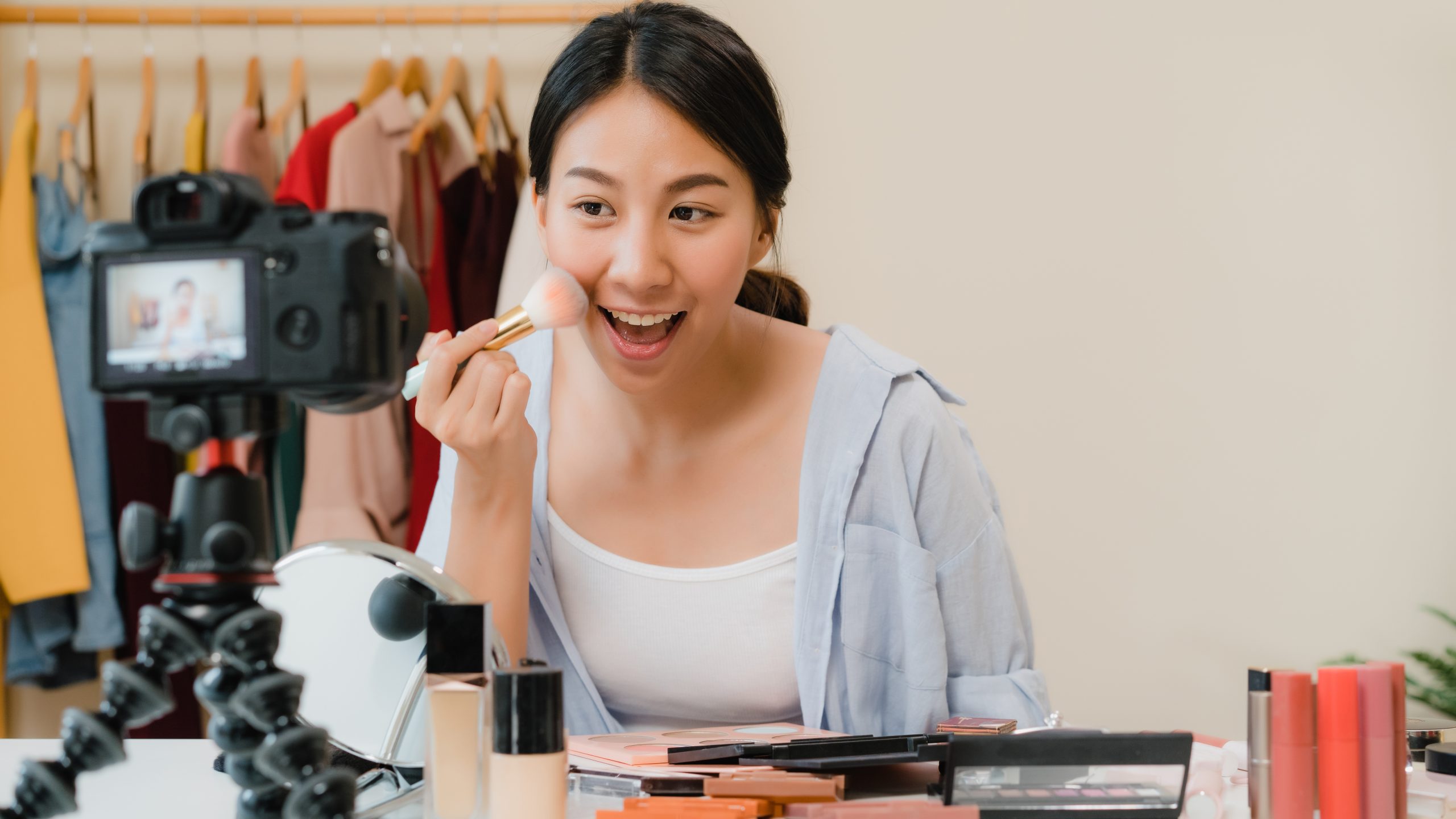 Beauty blogger present beauty cosmetics sitting in front camera for recording video. Beautiful asian woman use cosmetics review make up tutorial broadcast live video to social network by internet.